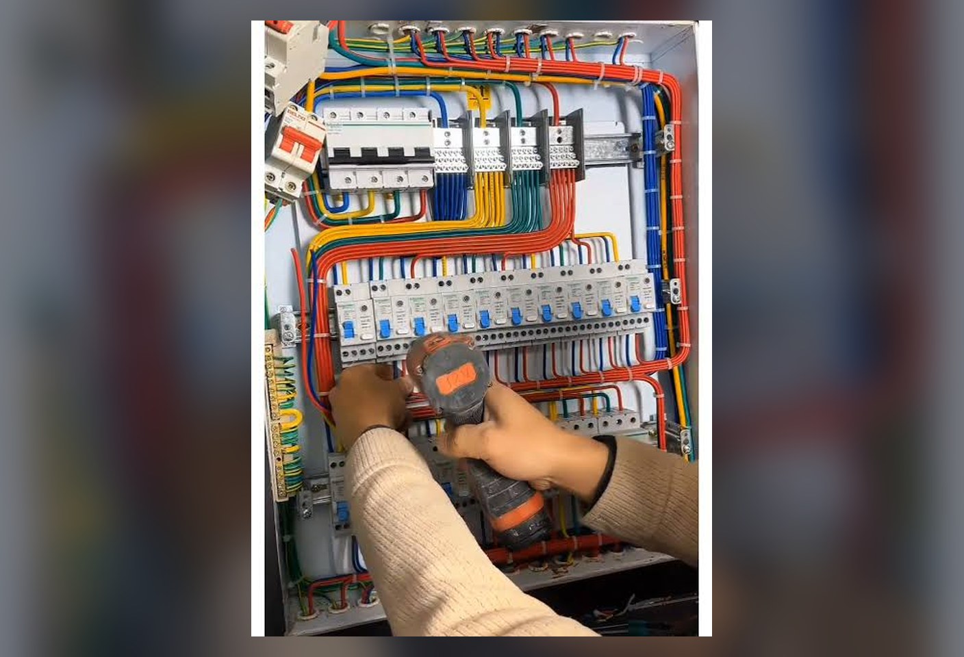 Electrician wiring a neatly terminated electrical distribution panel